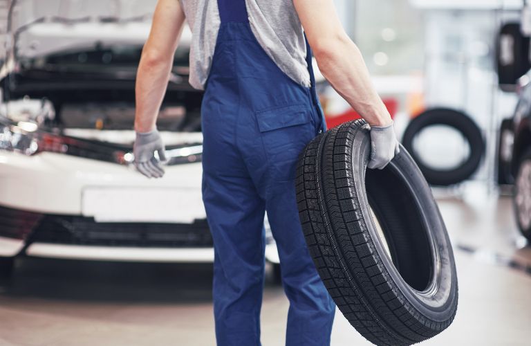 Technician carrying a tire after inspection